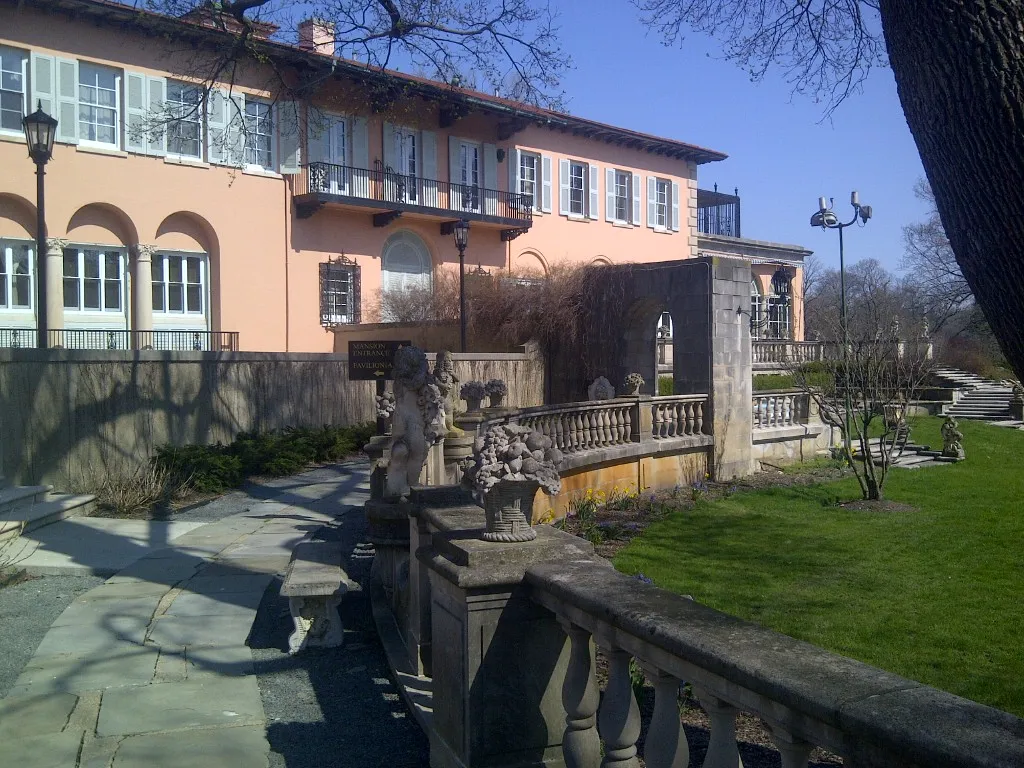 Cuneo Mansion in Vernon Hills with pale shutters, arched ground-floor windows and a stone garden terrace