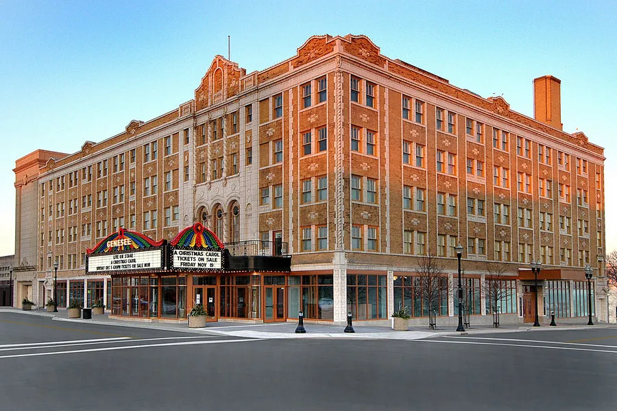 The brick Genesee Theatre building and illuminated entrance marquee on a downtown Waukegan street corner